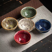 Colorful porcelain tea cups on a tea mat