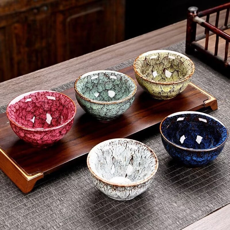 Five porcelain tea cups displayed on a tea tray