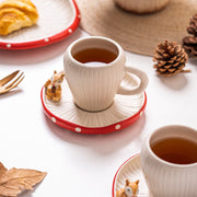 Red mushroom ceramic cup and saucer closeup with squirrel detail
